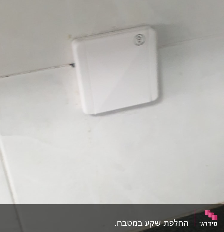 מתג חשמלי לבן על קיר לבן